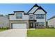A modern two-story home displays a white and black color scheme, brick accents, and an attached two-car garage at 167 S Harvest Ridge Way # Homesite 223, Wilson's Mills, NC 27520