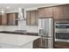 A modern kitchen features stainless steel appliances, dark wood cabinets, and a large island at 167 S Harvest Ridge Way # Homesite 223, Wilson's Mills, NC 27520