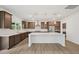 A spacious kitchen features stainless steel appliances, dark wood cabinets, and a large white countertop island at 167 S Harvest Ridge Way # Homesite 223, Wilson's Mills, NC 27520