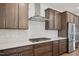 A modern kitchen features stainless steel appliances, dark wood cabinets, white quartz countertops, and patterned backsplash at 167 S Harvest Ridge Way # Homesite 223, Wilson's Mills, NC 27520