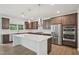A spacious kitchen features stainless steel appliances, dark wood cabinets, and a large white countertop island at 167 S Harvest Ridge Way # Homesite 223, Wilson's Mills, NC 27520