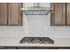 A kitchen showcases a stainless steel vent hood, stainless steel appliances, dark wood cabinets, and a patterned backsplash at 167 S Harvest Ridge Way # Homesite 223, Wilson's Mills, NC 27520