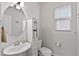 Charming powder room with a round mirror, pedestal sink, and a cabinet for ample storage at 1872 Stagecoach Trl, Wendell, NC 27591