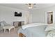 Neutral bedroom with a bed, wooden dresser, chair, and a mounted television at 1872 Stagecoach Trl, Wendell, NC 27591