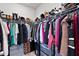 Walk-in closet with organized shelving and hanging rods, filled with clothing and shoes at 1872 Stagecoach Trl, Wendell, NC 27591