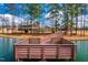 Scenic view of a wooden dock extending into a tranquil lake surrounded by lush trees at 1872 Stagecoach Trl, Wendell, NC 27591