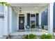 Charming front porch with seating and a welcoming 'hello' sign on the black front door at 1872 Stagecoach Trl, Wendell, NC 27591