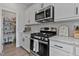 Kitchen with granite countertops, gas range, stainless steel microwave, and white cabinets at 1872 Stagecoach Trl, Wendell, NC 27591