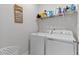 Well-organized laundry room with white appliances and a decorative laundry schedule sign above at 1872 Stagecoach Trl, Wendell, NC 27591