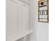 Well-organized mudroom with built-in bench, storage cubbies, and wall-mounted decorative metal storage containers and hooks at 1872 Stagecoach Trl, Wendell, NC 27591