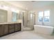Luxurious bathroom featuring marble floors, a glass shower, double vanity, and a standalone tub at 213 Big Bradley Dr, Wendell, NC 27591