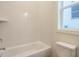 Bright bathroom featuring tiled walls, a bathtub, and a window, creating a clean and functional space at 213 Big Bradley Dr, Wendell, NC 27591