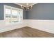 Elegant dining room featuring hardwood floors, wainscoting, and a modern chandelier at 213 Big Bradley Dr, Wendell, NC 27591