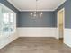 Spacious dining room with hardwood floors, wainscoting, a chandelier, and large windows at 213 Big Bradley Dr, Wendell, NC 27591