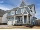 Beautiful two-story home featuring a covered porch, gray siding, and a two-car garage at 213 Big Bradley Dr, Wendell, NC 27591