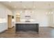 Spacious kitchen with a large island, white cabinets, hardwood floors, and modern lighting at 213 Big Bradley Dr, Wendell, NC 27591