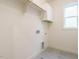 Functional laundry room features utility sink, storage, and tiled floor at 213 Big Bradley Dr, Wendell, NC 27591
