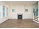Bright open-concept living room features a cozy fireplace and staircase to the upper level at 213 Big Bradley Dr, Wendell, NC 27591