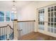 Well-lit staircase landing with hardwood floors, iron railings, and decorative glass doors at 213 Big Bradley Dr, Wendell, NC 27591
