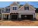 New two-story home with attached two-car garage, and a combination of gray siding and stone facade at 235 Augusta Pond Way # 161, Raleigh, NC 27603