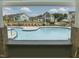 View of community pool from covered patio, featuring lounge chairs and blue umbrellas at 235 Augusta Pond Way # 161, Raleigh, NC 27603