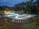 Community pool featuring lounge chairs and umbrellas in a wooded surrounding at dusk at 235 Augusta Pond Way # 161, Raleigh, NC 27603