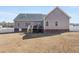 Backyard showcasing the home's exterior, a small deck, and a mix of green and dry grass at 2570 Sweet Bay Rd, Rocky Mount, NC 27804