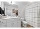 Clean, well-lit bathroom with white cabinets, a large mirror, and a shower with striped curtain at 2570 Sweet Bay Rd, Rocky Mount, NC 27804