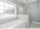 Bright bathroom features a separate soaking tub, stand up shower, and natural light at 2570 Sweet Bay Rd, Rocky Mount, NC 27804