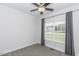 Cozy bedroom featuring a ceiling fan, plush carpet, and a large window for natural light at 2570 Sweet Bay Rd, Rocky Mount, NC 27804