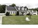Two-story home with stone and vinyl siding, a welcoming front porch, and a well-manicured lawn at 2570 Sweet Bay Rd, Rocky Mount, NC 27804