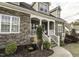 Charming front porch with stone accents, white railings, and decorative landscaping at 2570 Sweet Bay Rd, Rocky Mount, NC 27804