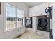 Well-lit laundry room with modern washer and dryer, built-in cabinets, and a window at 2570 Sweet Bay Rd, Rocky Mount, NC 27804
