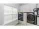 Well-lit laundry room boasts modern washer and dryer units with overhead cabinet storage at 2570 Sweet Bay Rd, Rocky Mount, NC 27804