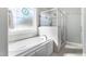 This bathroom boasts a glass-enclosed shower and a standalone tub under a window with decorative glass at 2570 Sweet Bay Rd, Rocky Mount, NC 27804