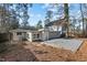 A backyard featuring a gray deck and exterior of the home with glass door and white trim windows surrounded by mature trees at 2603 Legion Ave, Durham, NC 27707