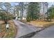 A long driveway leading to the home with a partial front view, enveloped by mature trees and front yard landscaping at 2603 Legion Ave, Durham, NC 27707