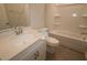 Bright bathroom featuring granite vanity, under-sink storage, toilet, and bathtub with tiled walls at 2715 Hunter Woods Dr # 562, Apex, NC 27502