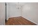 A well-lit dining room showcasing hardwood flooring, a classic chandelier, and minimalist wall decor at 3027 Maple Ave # D2, Burlington, NC 27215