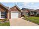 Charming brick home featuring an attached garage, well-manicured lawn, and mature landscaping at 3027 Maple Ave # D2, Burlington, NC 27215
