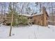 Rear exterior view of the brick home with wood deck and stairway covered in snow at 3412 Hackney Ct, Raleigh, NC 27613