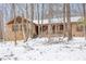 Charming brick home featuring a covered porch and wintery wooded surroundings at 3412 Hackney Ct, Raleigh, NC 27613