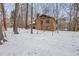 View of the brick house exterior surrounded by snow covered ground and bare trees at 3412 Hackney Ct, Raleigh, NC 27613