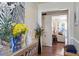 Inviting hallway featuring hardwood floors, decorative art, and a view into a sunlit living space at 400 Cedarmere Dr, Wendell, NC 27591