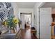 Inviting hallway featuring hardwood floors, decorative art, and a view into a sunlit living space at 400 Cedarmere Dr, Wendell, NC 27591