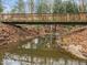 Scenic wooden bridge spanning a tranquil stream, perfect for leisurely strolls at 401 Oak Hollow Ct, Raleigh, NC 27613