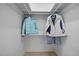 Organized walk-in closet with hanging jackets and storage space above at 401 Oak Hollow Ct, Raleigh, NC 27613
