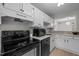 Efficient kitchen layout with white cabinetry, modern appliances, and ample counter space at 401 Oak Hollow Ct, Raleigh, NC 27613