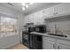 Bright kitchen featuring white cabinets, black appliances, and a window view at 401 Oak Hollow Ct, Raleigh, NC 27613