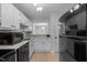 Modern kitchen with white cabinets, black appliances, and a view into the next room at 401 Oak Hollow Ct, Raleigh, NC 27613